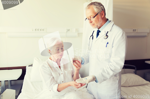 Image of doctor giving medicine to senior woman at hospital