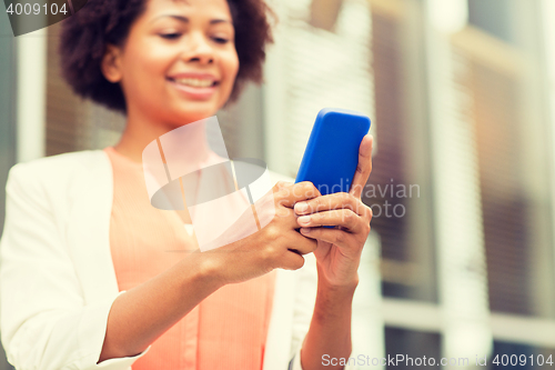 Image of close up of african woman with smartphone in city