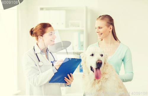 Image of happy doctor with retriever dog at vet clinic