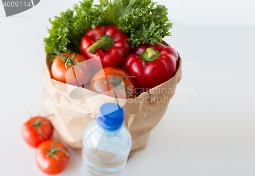 Image of basket of fresh vegetables and water at kitchen