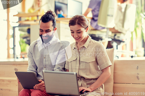 Image of creative team with tablet pc and laptop in office