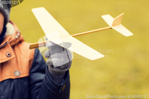 Image of close up of little boy holding toy plane outdoors