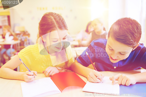 Image of group of school kids writing test in classroom