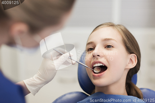 Image of female dentist checking patient girl teeth