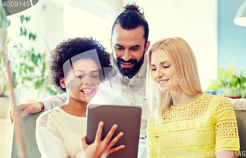 Image of happy creative team with tablet pc in office