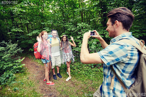 Image of friends with backpack taking selfie by smartphone