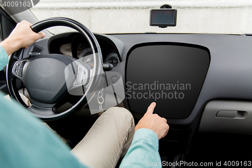 Image of man driving car and pointing to on-board computer