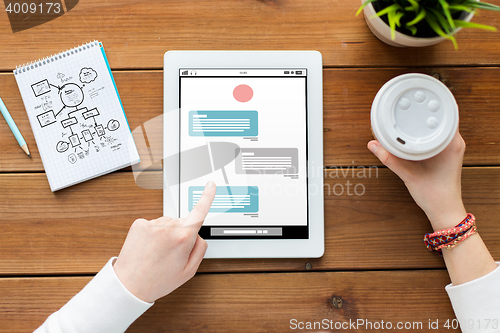 Image of close up of woman with tablet pc on wooden table