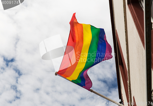 Image of close up of rainbow gay pride flag waving on building