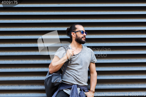 Image of man with backpack standing at city street wall