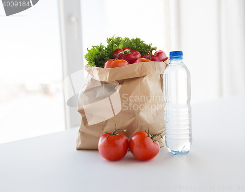Image of basket of fresh vegetables and water at kitchen