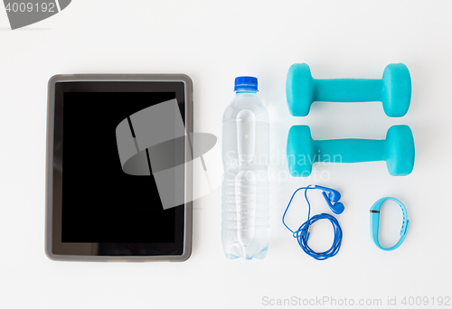 Image of tablet pc, dumbbells, earphones and bottle