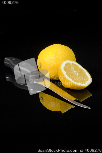 Image of lemon and kitchen knife with black background