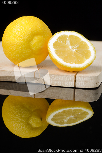 Image of lemon on wood table with black background