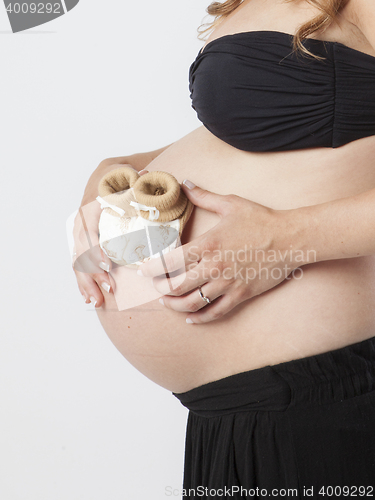 Image of Pregnant Woman holding her hands on beautiful belly