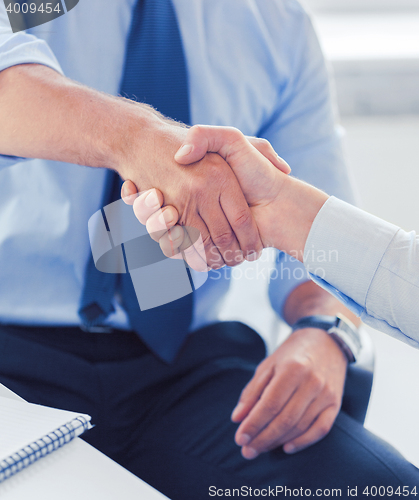 Image of businessmen shaking hands in office