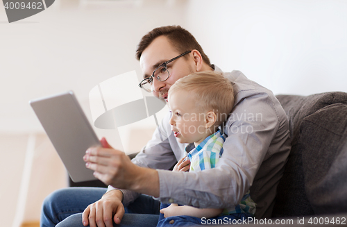 Image of father and son with tablet pc playing at home