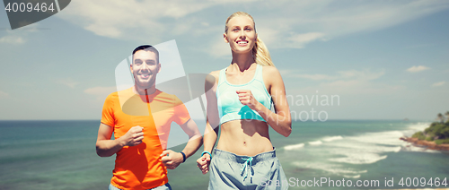 Image of happy couple running over sea or beach background