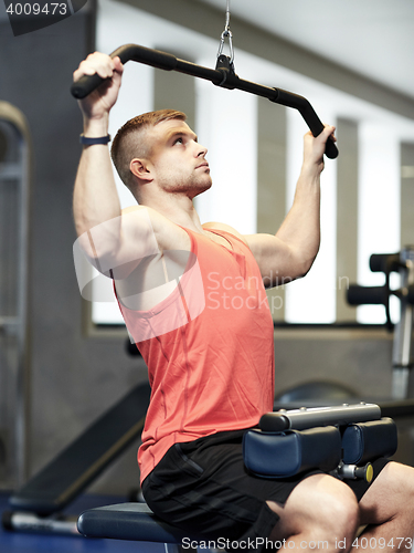 Image of man flexing muscles on cable machine gym