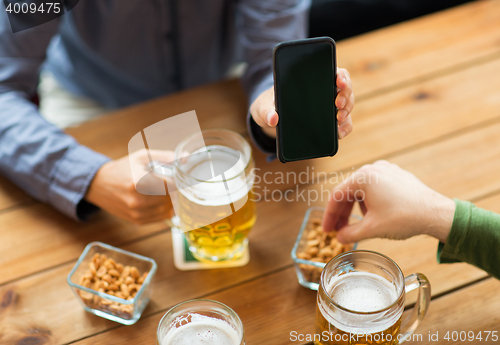 Image of close up of friends with smartphone and beer