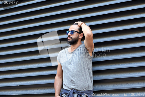 Image of man with beard and sunglasses on city street