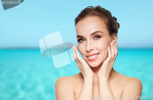 Image of beautiful young woman touching her face