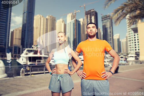 Image of couple exercising over dubai city background