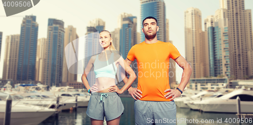 Image of couple exercising over dubai city background