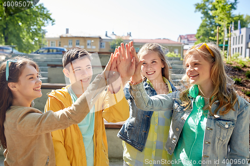 Image of happy students or friends making high five