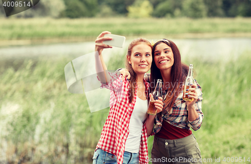 Image of happy women taking selfie by smartphone outdoors