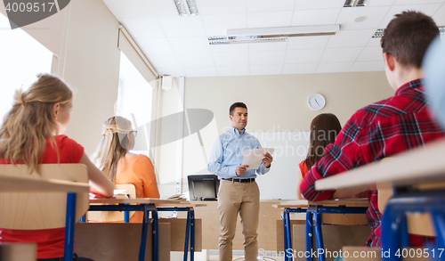 Image of group of students and teacher with papers or tests