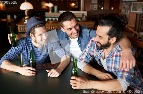 Image of happy male friends drinking beer at bar or pub