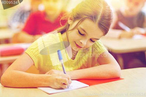 Image of group of school kids writing test in classroom