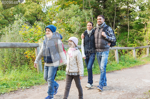 Image of happy family with backpacks hiking in woods