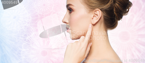 Image of beautiful woman pointing finger to her ear