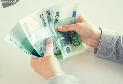 Image of close up of woman hands counting euro money