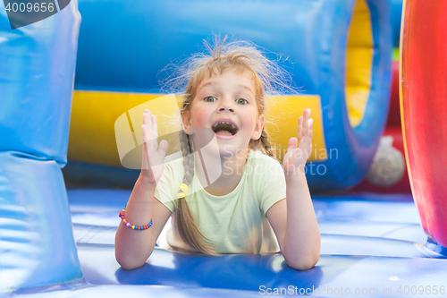 Image of Happy girl lying on a big inflatable trampoline game