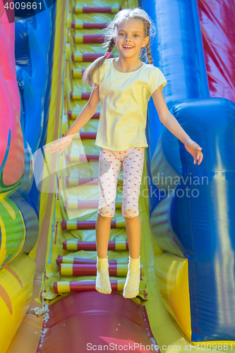 Image of Happy girl jumping on an inflatable trampoline