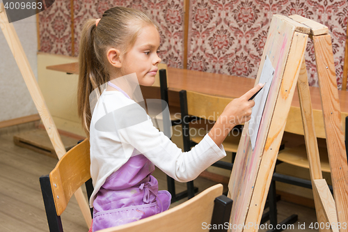 Image of Girl artist with a smile look in the picture on the drawing lesson