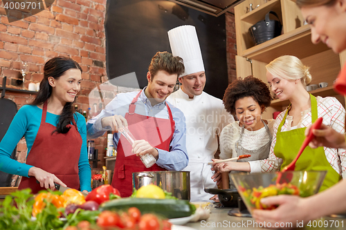 Image of happy friends and chef cook cooking in kitchen