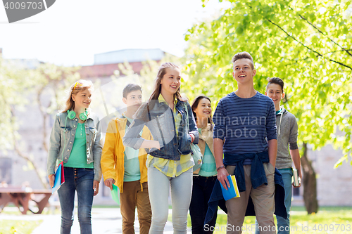 Image of group of happy teenage students walking outdoors