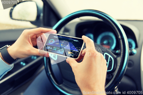 Image of hands with navigator on smartphone in car