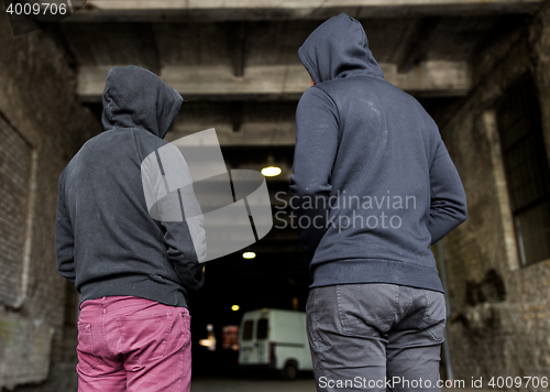 Image of addict men or criminals in hoodies on street