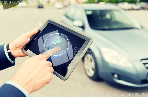 Image of close up of hands with car starter on tablet pc