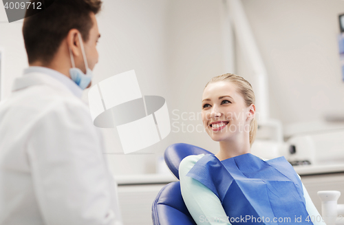 Image of happy male dentist with woman patient at clinic