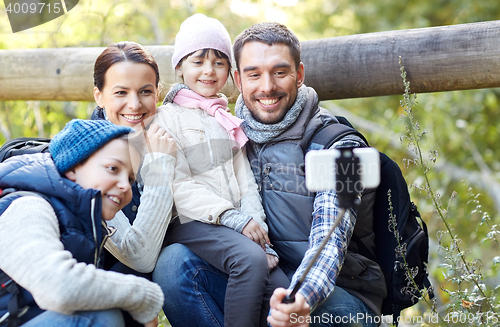 Image of happy family with smartphone selfie stick in woods