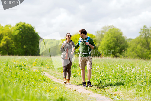 Image of happy couple with backpacks hiking outdoors