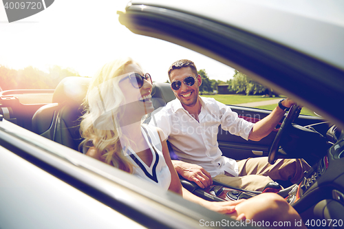 Image of happy man and woman driving in cabriolet car