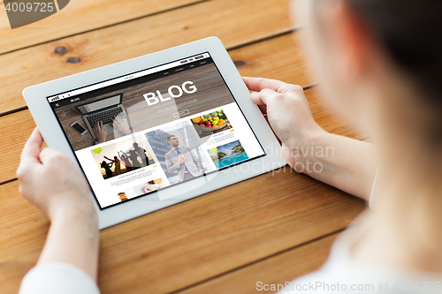 Image of close up of woman with tablet pc on wooden table