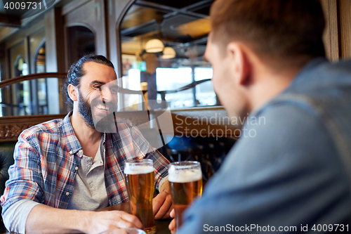 Image of happy male friends drinking beer at bar or pub